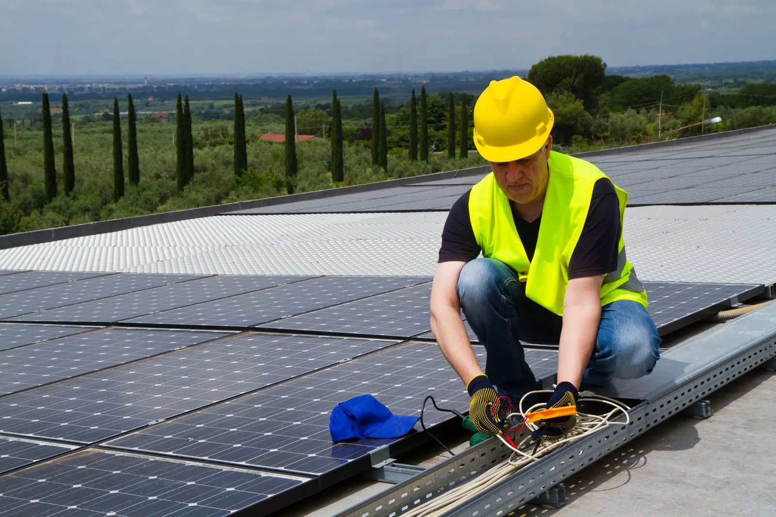 Technician maintaining rooftop solar panels
