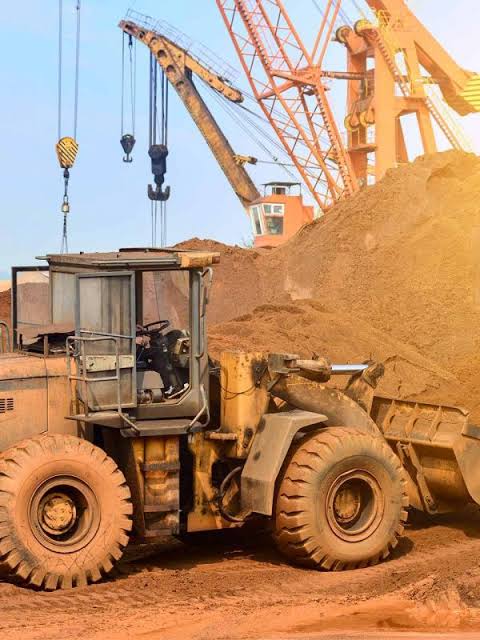 Construction worker operating heavy machinery at dusk